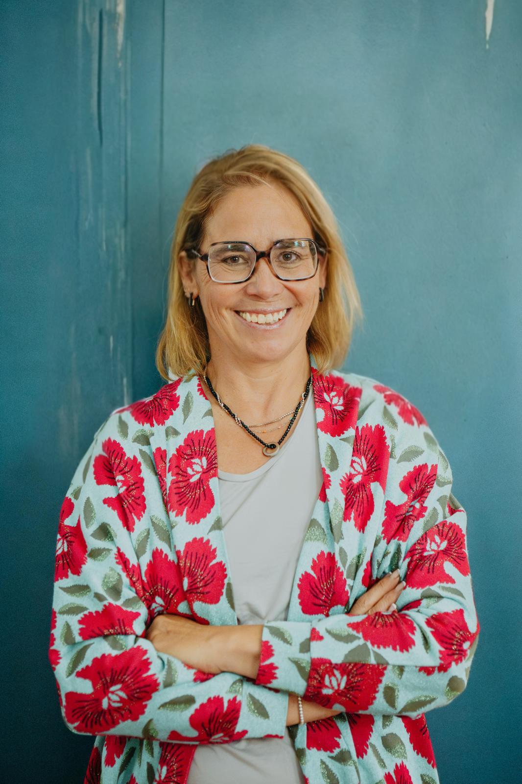 Dr. Aline Steinbrecher, Mentalcoach, vor einer petrolblauen Wand
